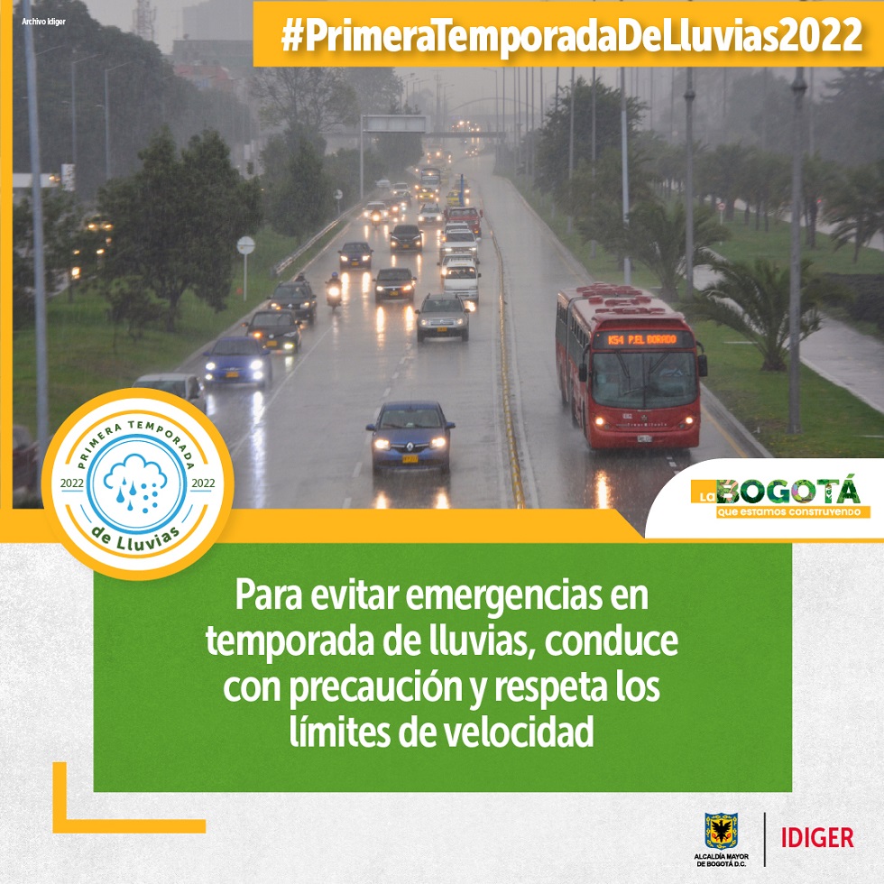 Carros y buses transitando por vía con encharcamientos