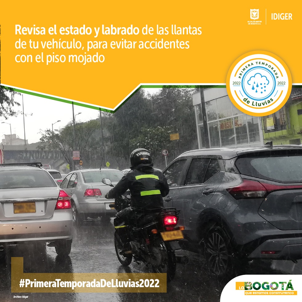 Vehículos y moto transitando por vía con lluvia